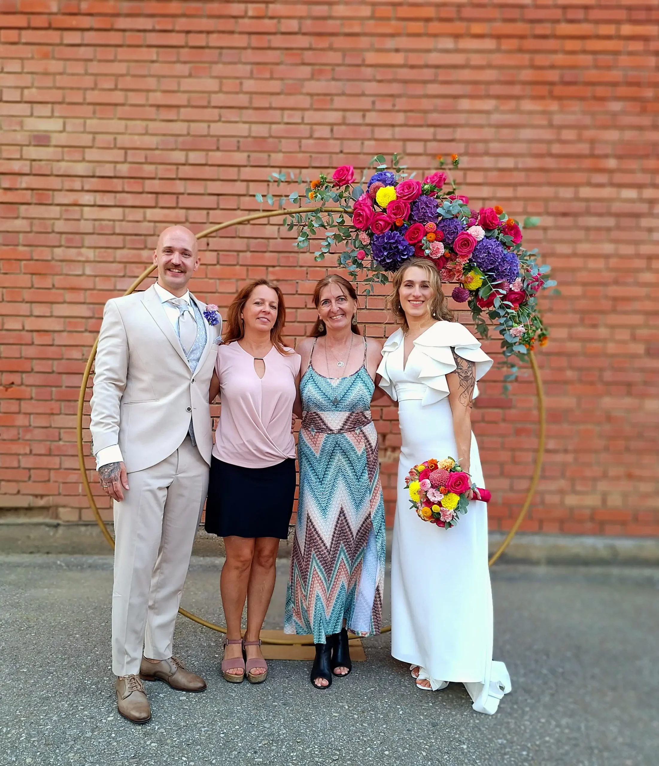 Hochzeitspaar mit deutsch-ungarischen Trauredner vor einem Traubogen