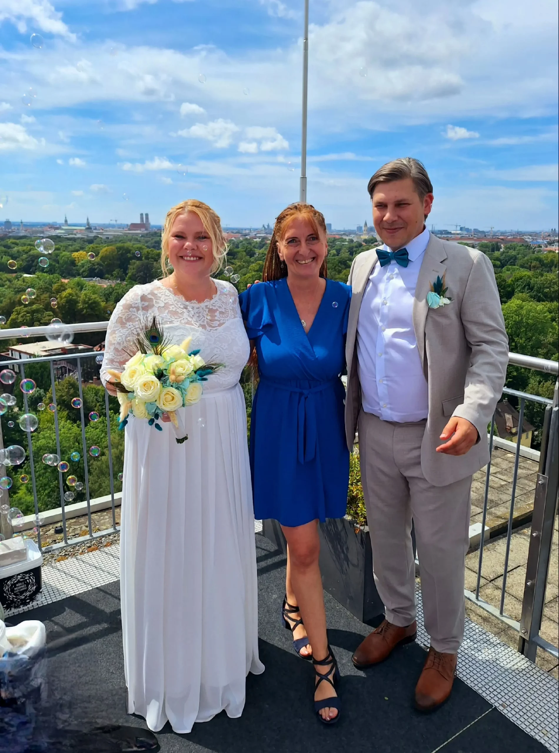 Hochzeitspaar und Traurednerin auf der Dachterrasse vom Hilton Hotel in München