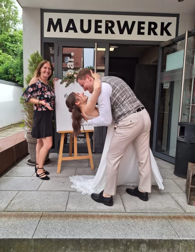 Hochzeitspaar und Traurednerin vor dem Mauerwerk in Herrenberg